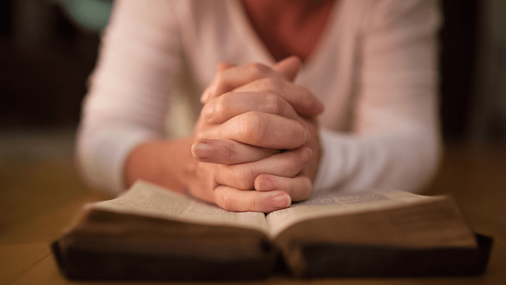 Person praying with hands clasped