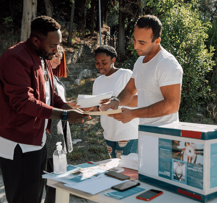 Outdoor meeting with paperwork and sanitizer