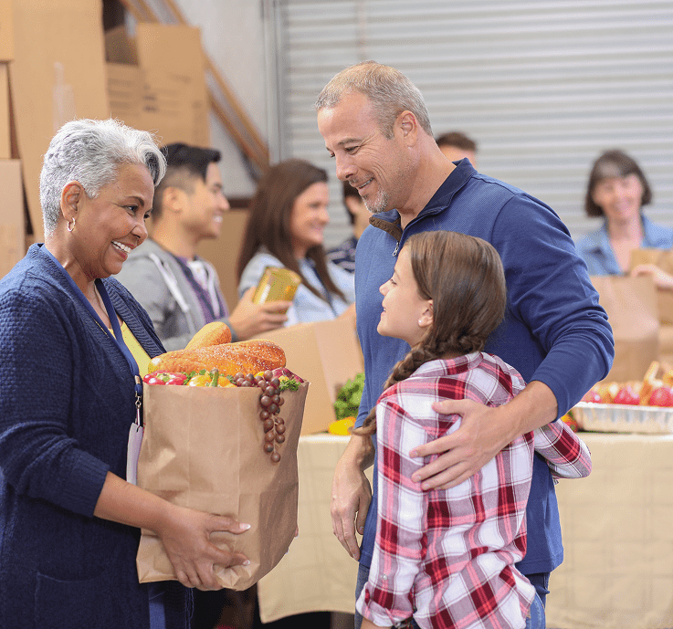 Smiling volunteers helping with food donations
